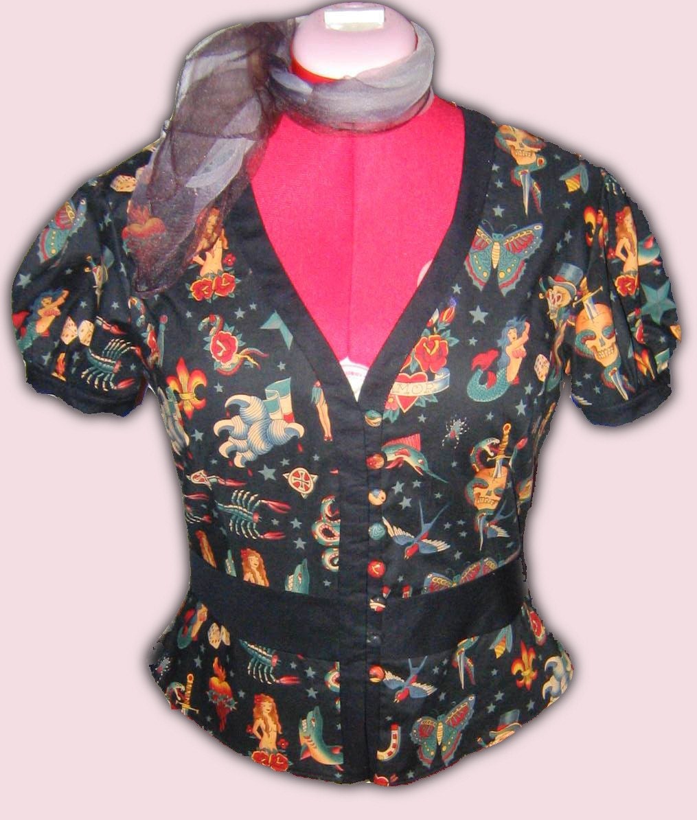It is made of a cotton tattoo flash print fabric and has puffed sleeves, 